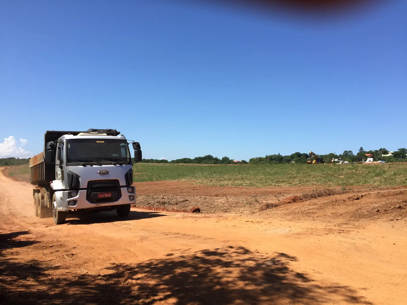 Caminhão basculante em estrada de terra de obra de terraplenagem